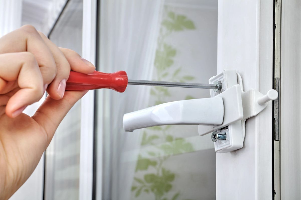 Image of someone fixing a window handle.